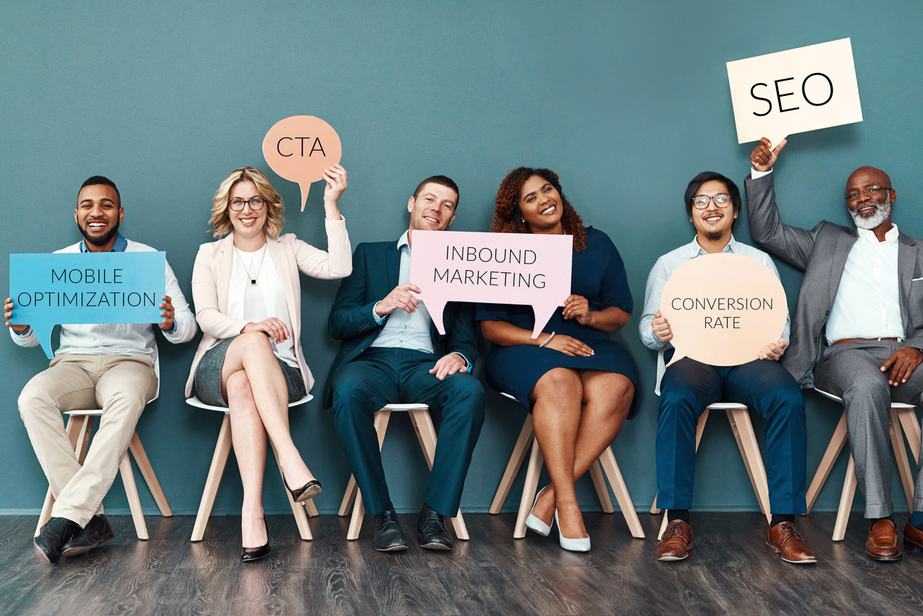 working professionals holding signs that say mobile optimization, CTA, Inbound Marketing, Conversion Rate and SEO